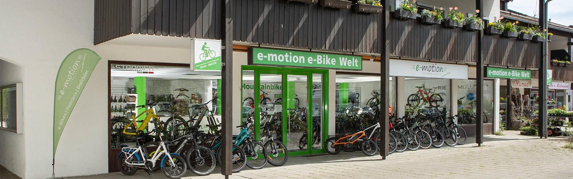 Das Bild zeigt die Fassade eines E-Bike Shops in München Süd, betitelt als "e-motion e-Bike Welt".