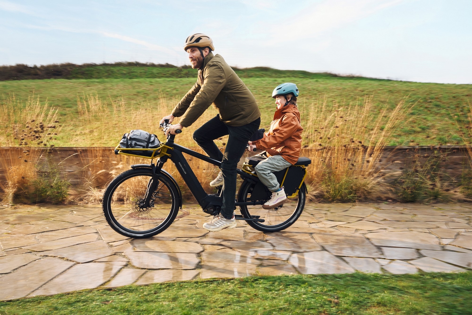 Das Bild zeigt einen Mann und ein Kind auf einem Riese & Müller Multicharger