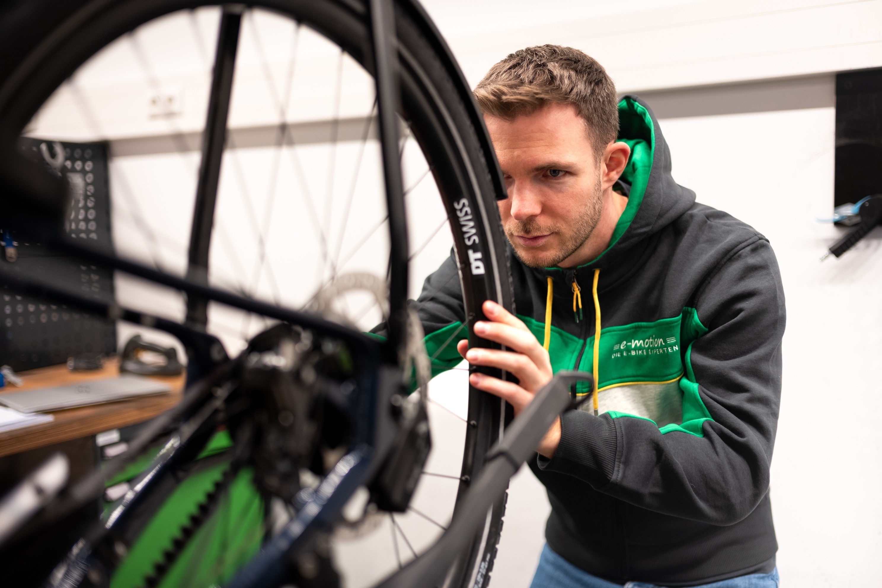 Ein e-motion Werkstattmitarbeiter arbeitet an einem Rad eines e-Bikes