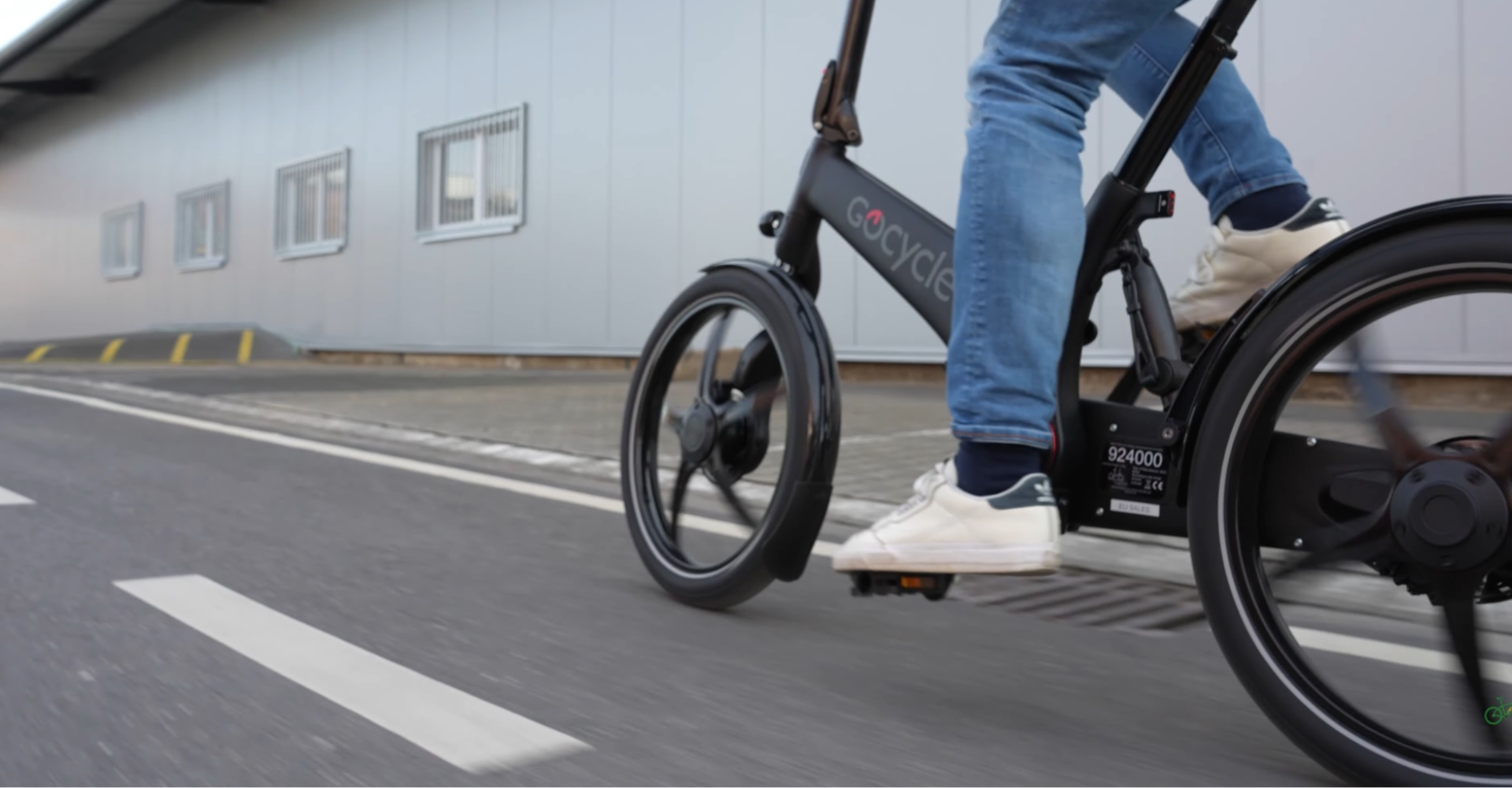 Ein Mann fährt auf einem GoCycle Klapprad durch ein Industriegebiet.