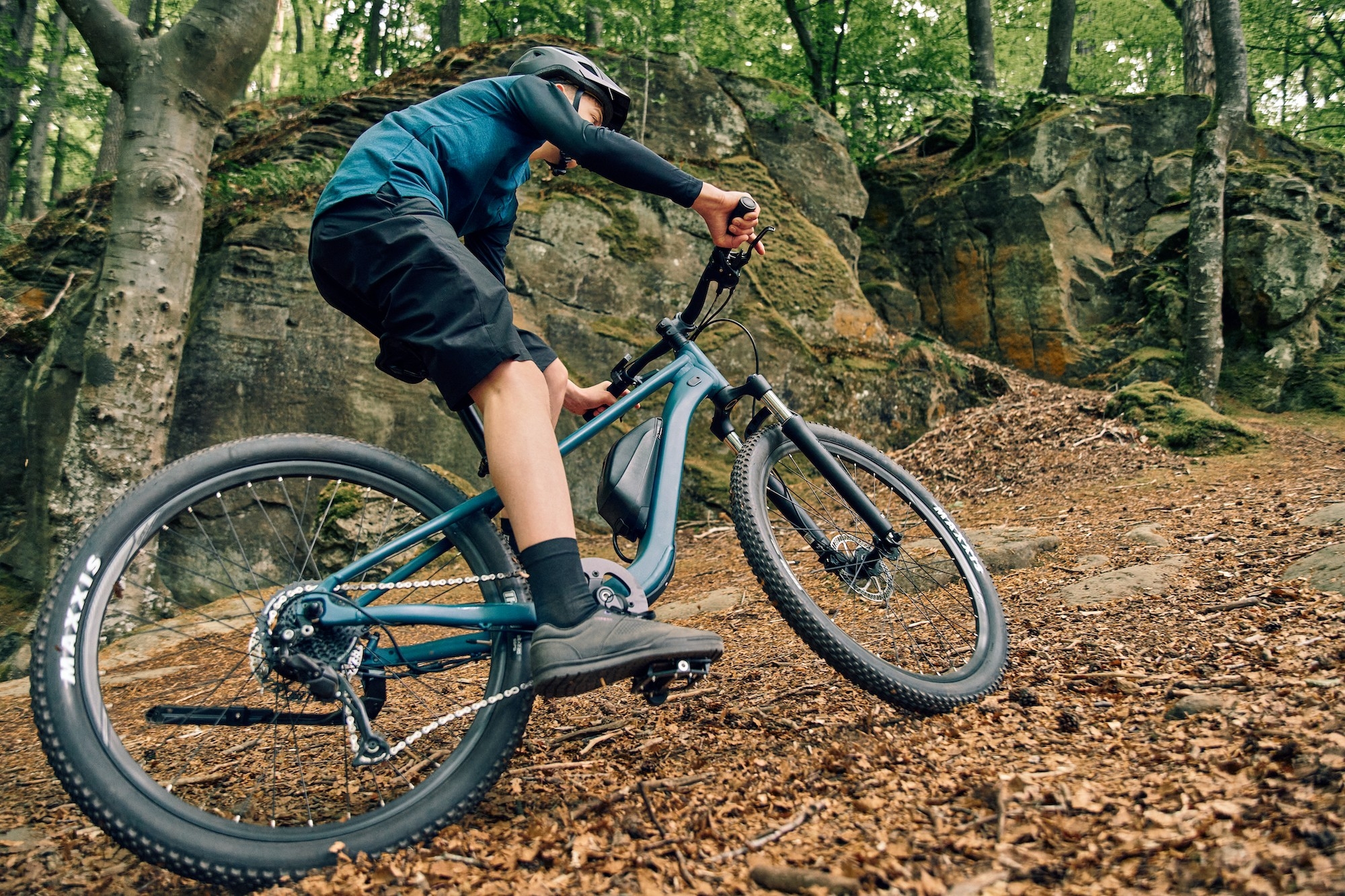 Fahrer auf einem e-Mountainbike auf einem anspruchsvollen Trail im Wald