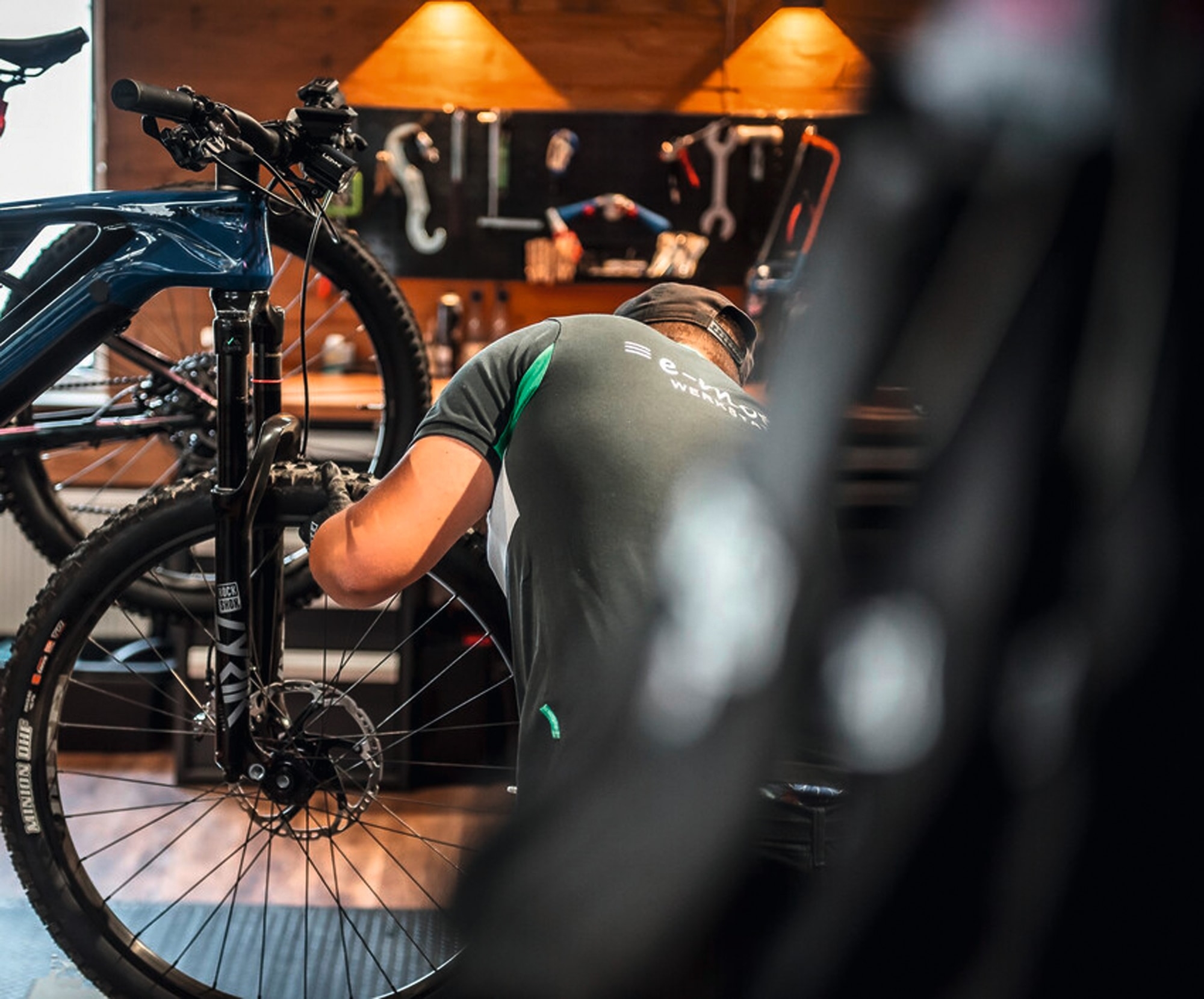 Ein Mechaniker inspiziert ein E-Bike in einer professionellen Werkstatt. Perfekt für Liebhaber von hochwertiger Fah