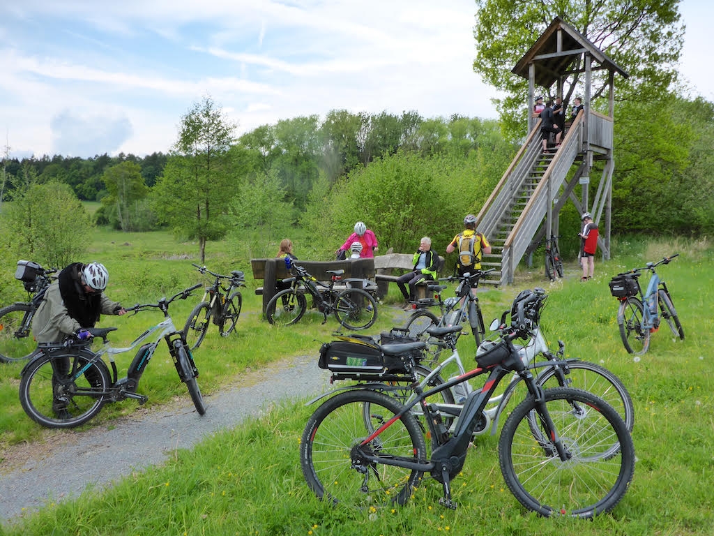 Eine Gruppe von Radfahrern genießt einen Ausflug mit E-Bikes in einer idyllischen Naturlandschaft.