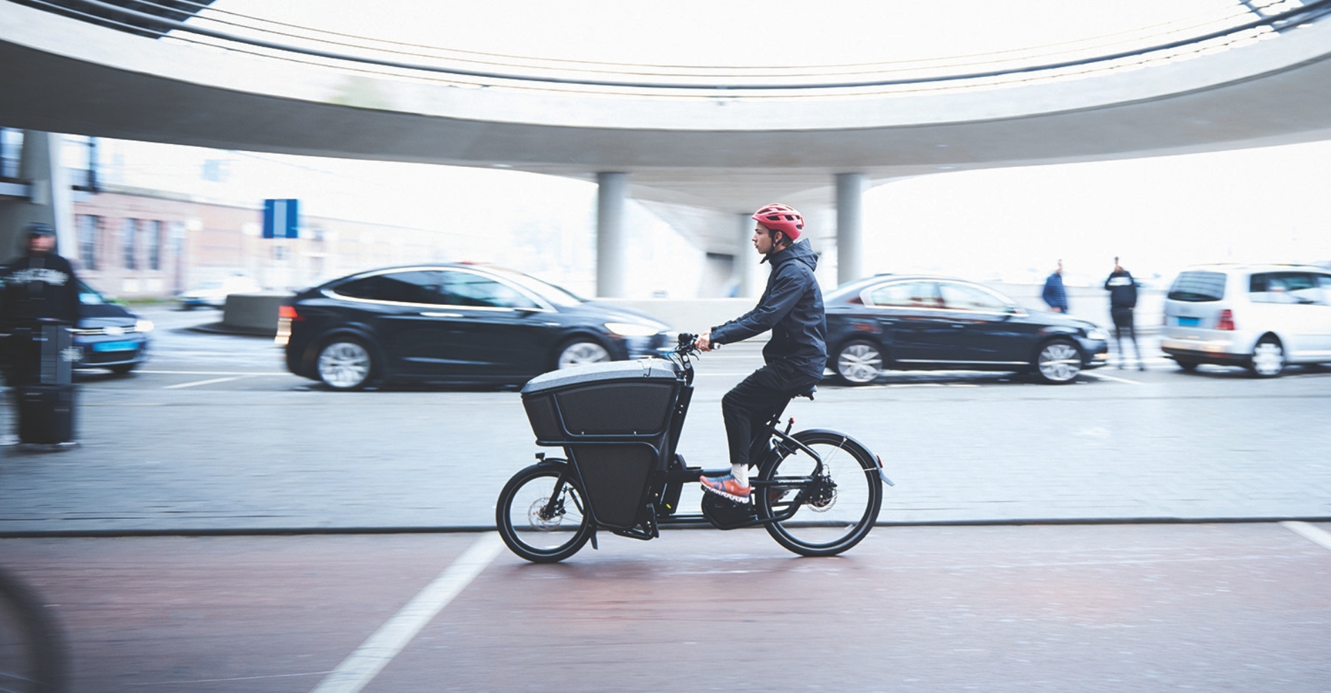 Im Rahmen der Lastenrad Förderung in Frankfurt fährt ein Mann mit einem Lastenrad gerade durch die Stadt.