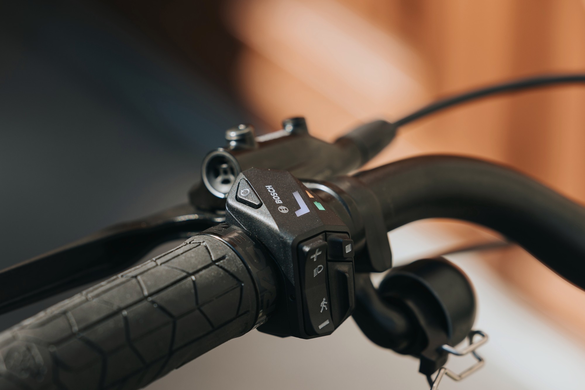 Das Bild zeigt die Steuerungseinheit der Bosch e-Bike Hub Line, montiert am Lenker eines E-Bikes.