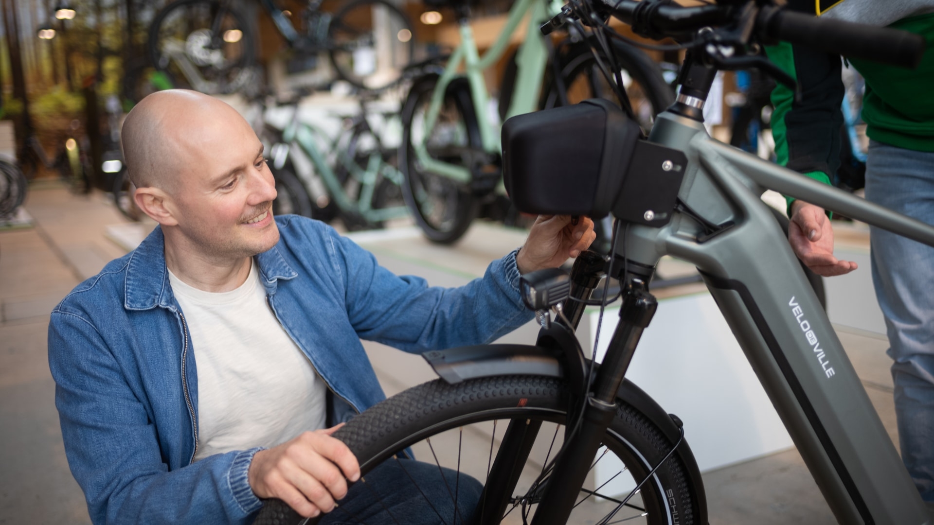 Ein Fahrer analysiert ein Velo de Ville E-Bike. Entdecke hochwertige E-Bike-Komponenten für optimale Leistung und K