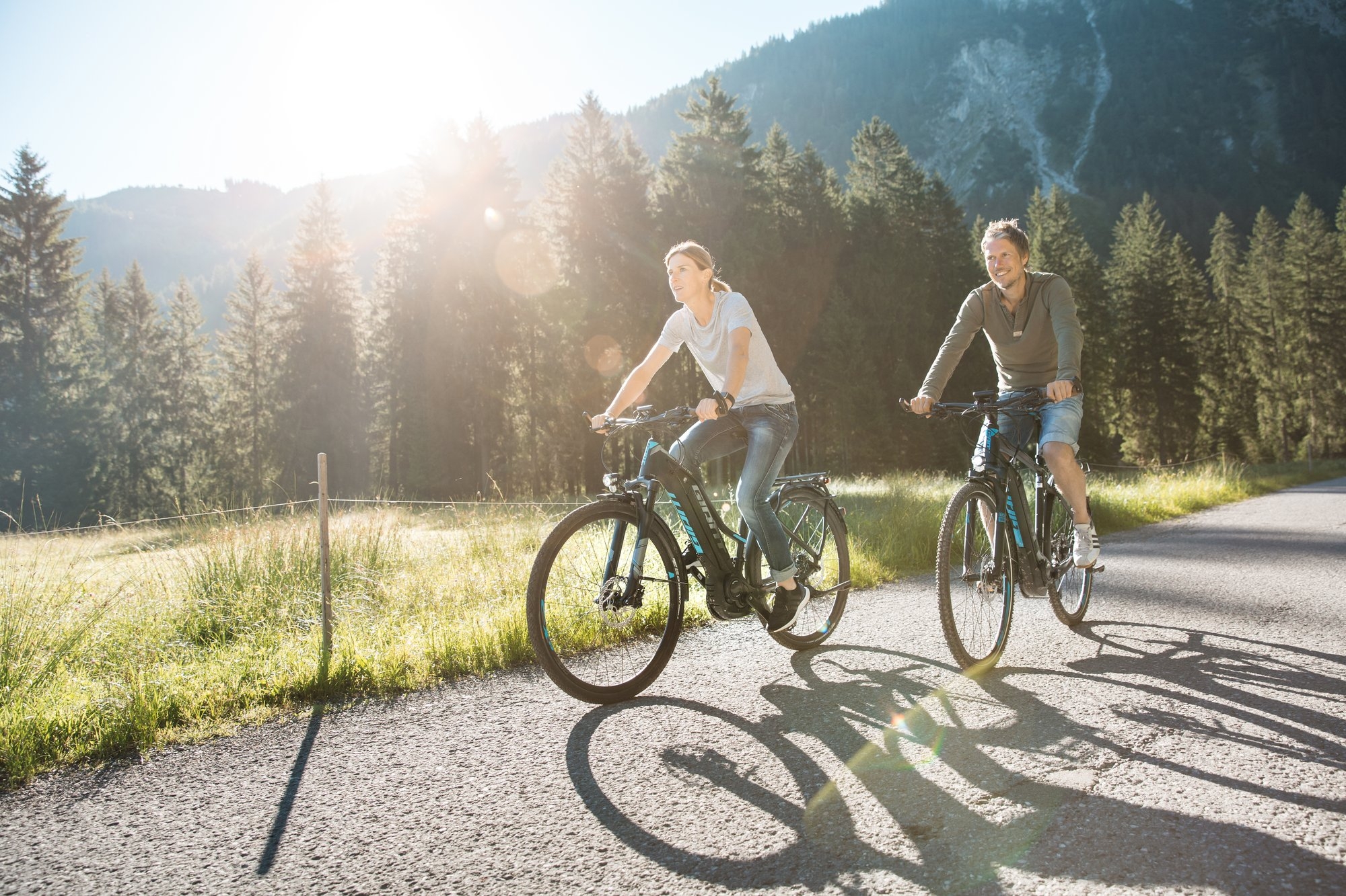 Das Bild zeigt zwei glückliche e-Bike-Fahrer in der Natur