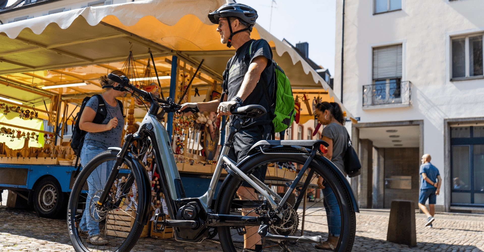 Ein Mann schiebt sein Cannondale Tesoro Neo X 1 e-Bike über einen Markt
