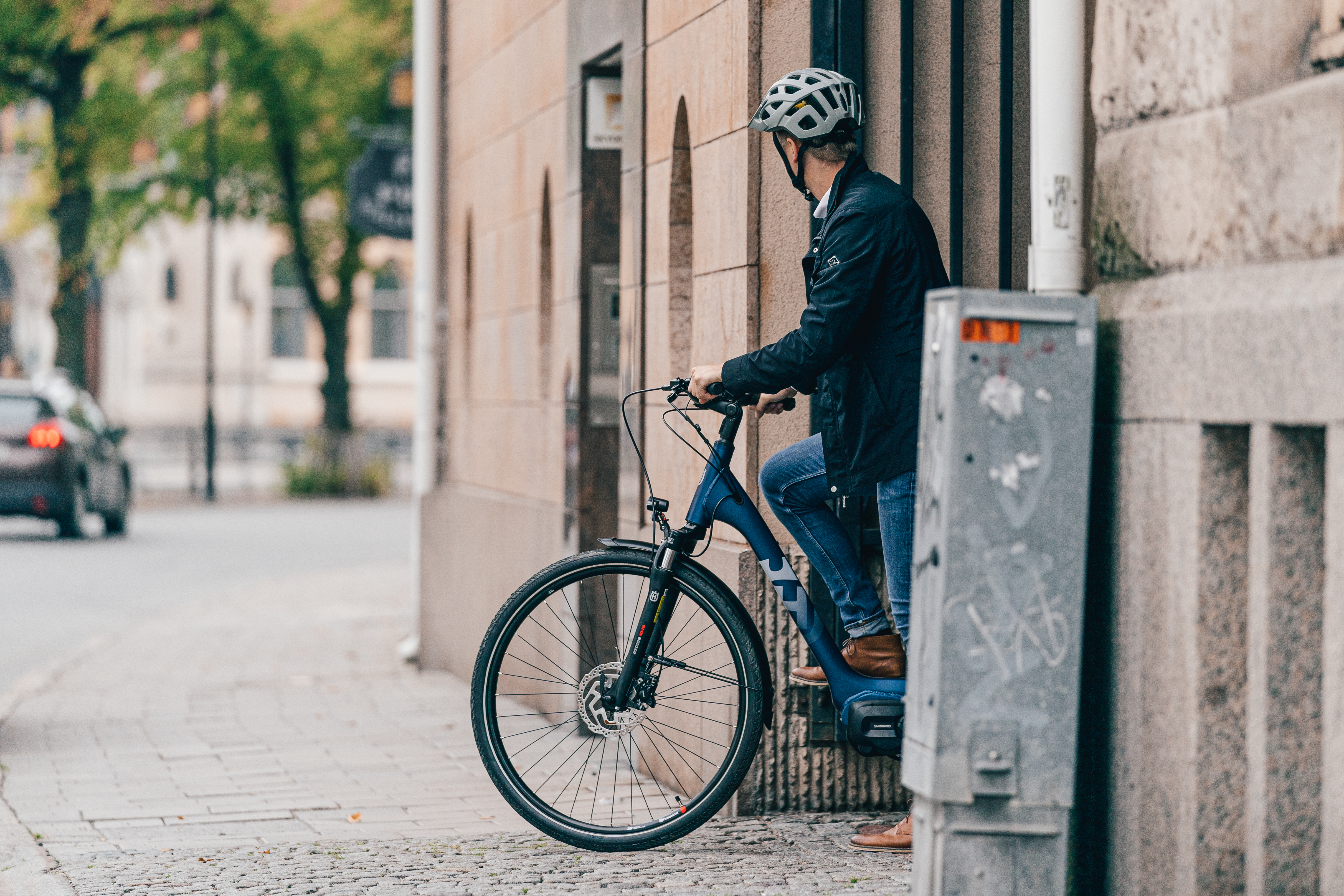 Ein junger Mann fährt in Gießen mit seinem e-Bike aus einer Einfahrt, auf dem Weg zur Arbeit.