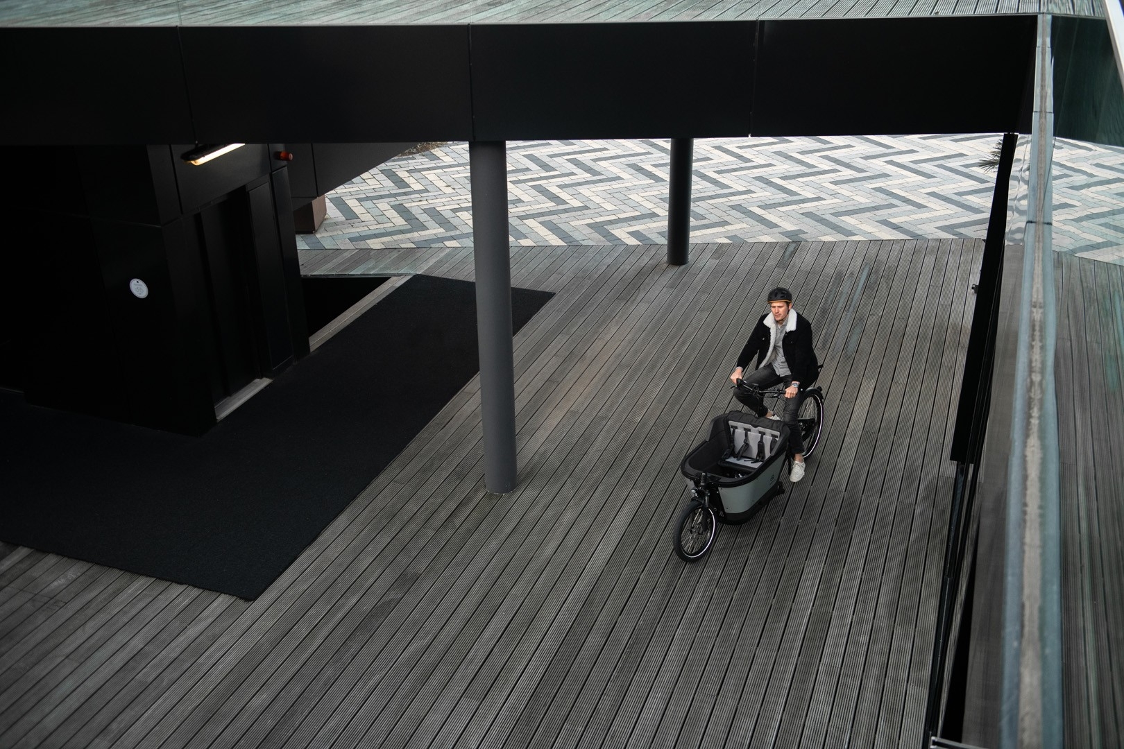 Das Bild zeigt ein Carqon Cruise e-Bike, dass in einer modernen urbanen Umgebung dargestellt ist.