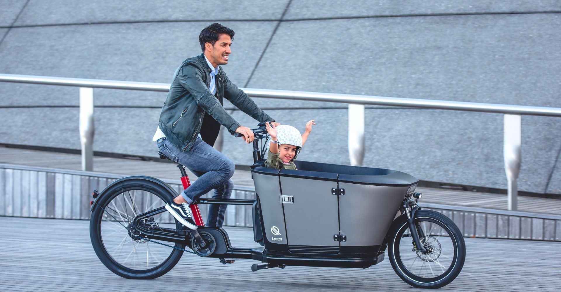 Ein Mann fährt auf dem Carqon Classic mit Kind in der Transportbox