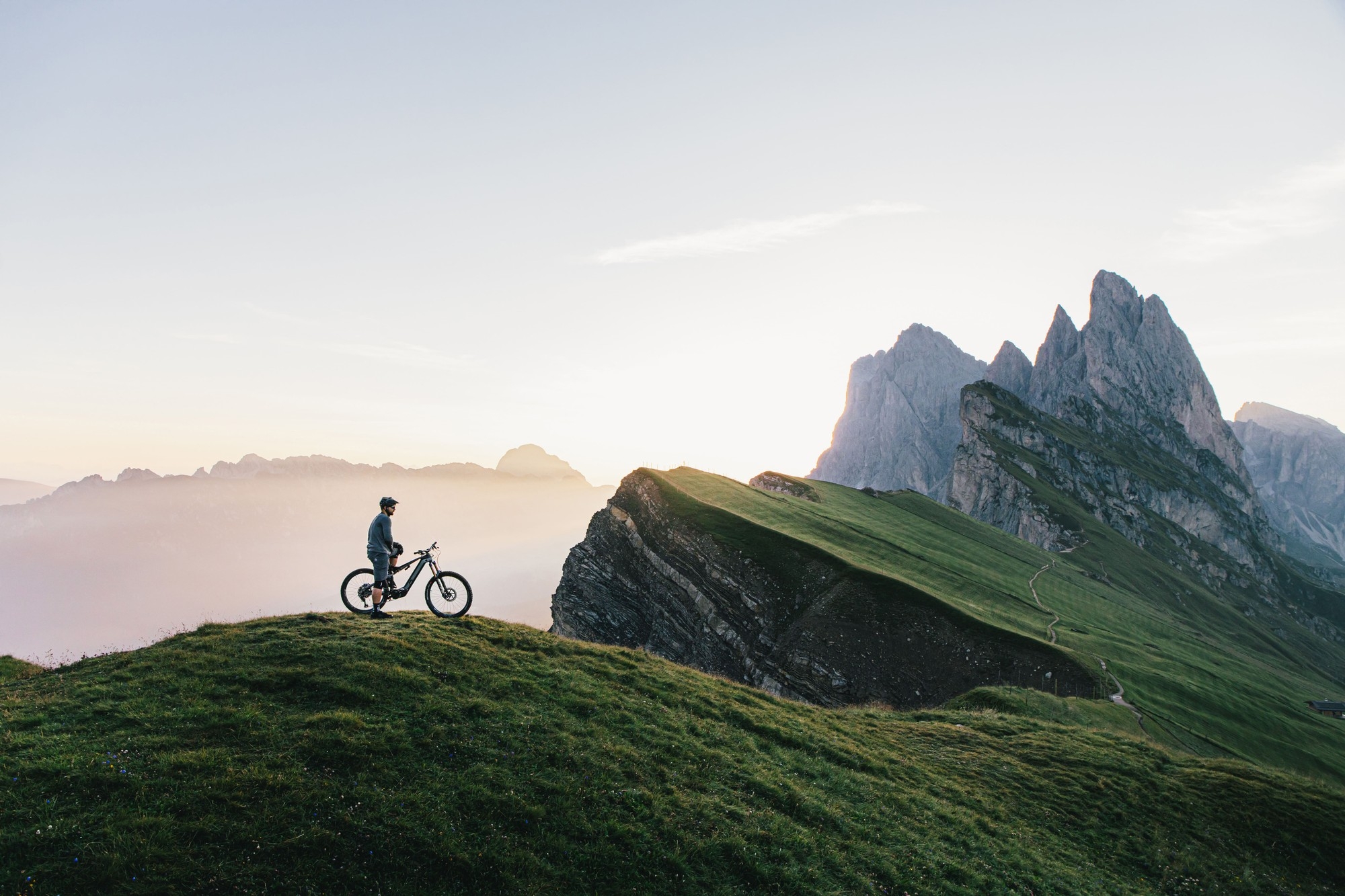 Das Bild zeigt einen Radfahrer, der auf einem E-Bike in der faszinierenden Berglandschaft des Erzbergs steht.