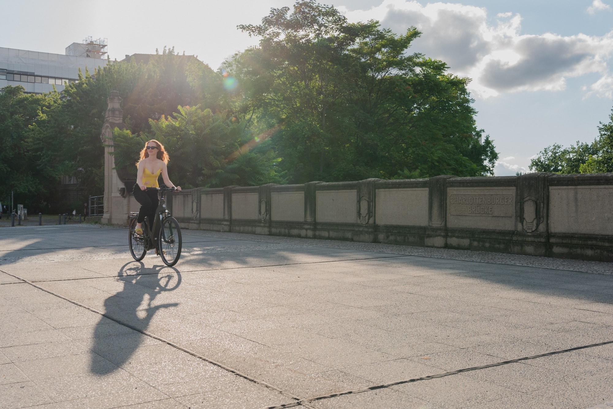 Eine Frau fährt auf einem E-Bike über die Charlottenburger Brücke. Perfektes Wetter für eine entspannte Fahrradtour