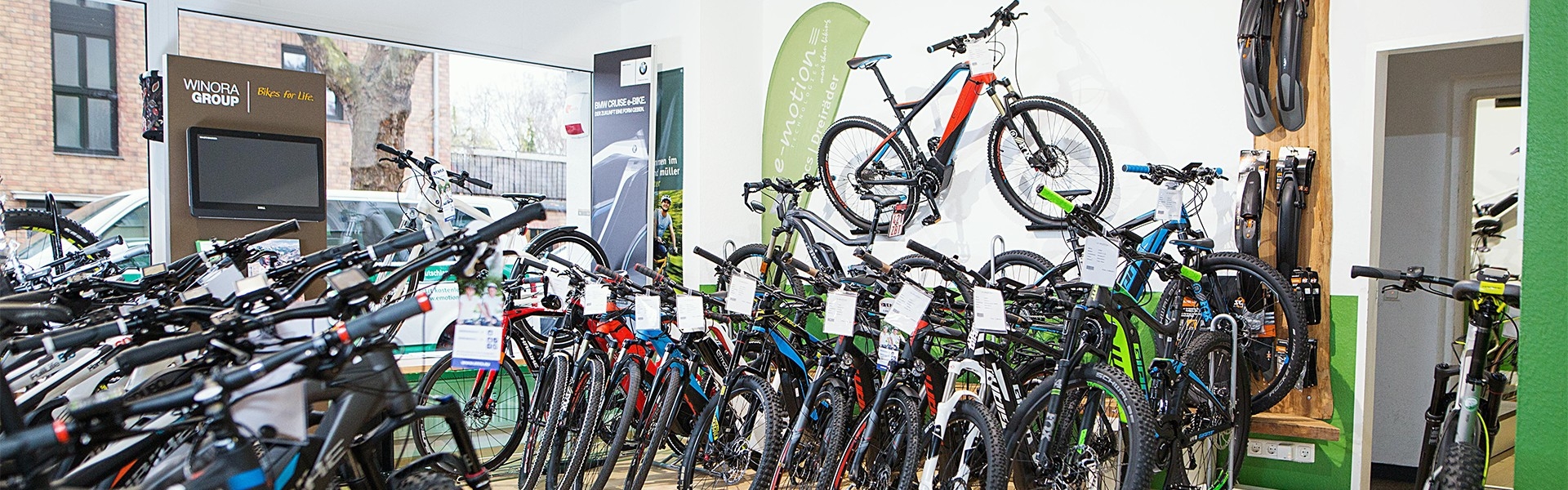 Das Bild zeigt einen gut ausgestatteten Fahrradshop in Köln, der eine große Auswahl an E-Bikes präsentiert.