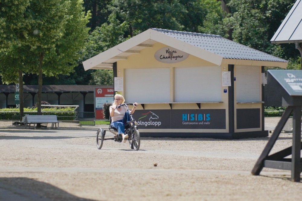 Eine Frau fährt ein Dreirad auf freier Strecke Probe