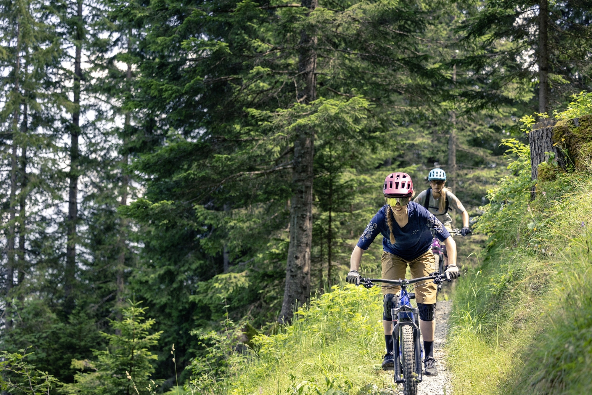 Zwei Personen fahren mit Bosch E-Bikes auf einem Waldpfad. Perfekt für abenteuerliche Touren in der Natur.