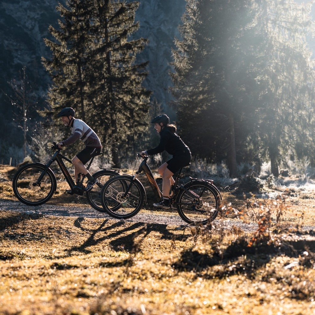 Auf dem Bild sind ein Mann und eine Frau auf einem Trekking e-Bike abgebildet.