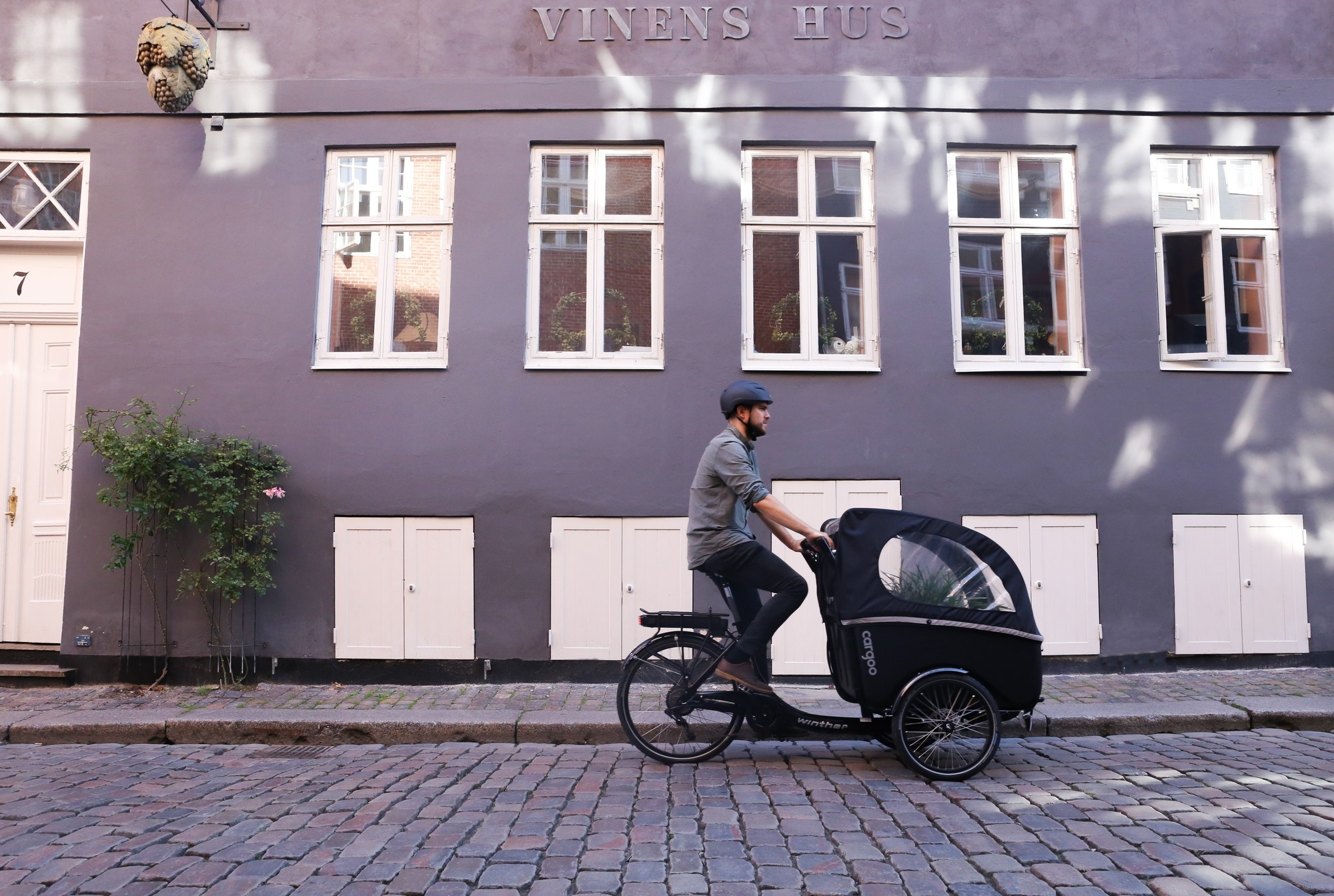 Ein Mann fährt auf dem Winther Cargoo Lastenrad durch die Stadt