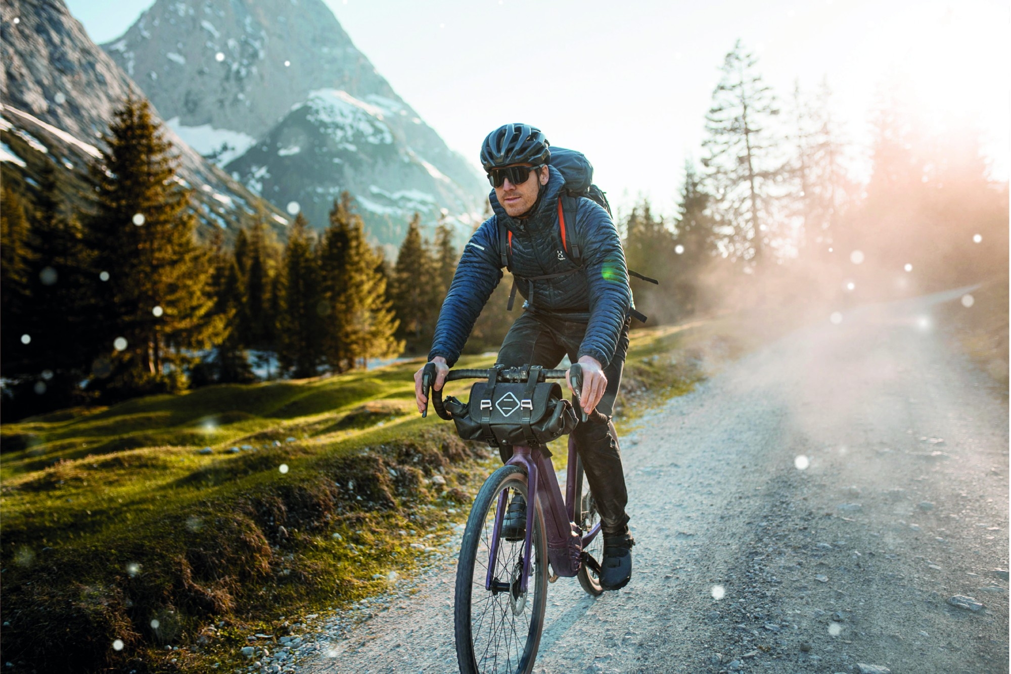 Das Bild zeigt einen Radfahrer auf einem Giant Revolt E+ e-Bike in einer malerischen, bergigen Umgebung.
